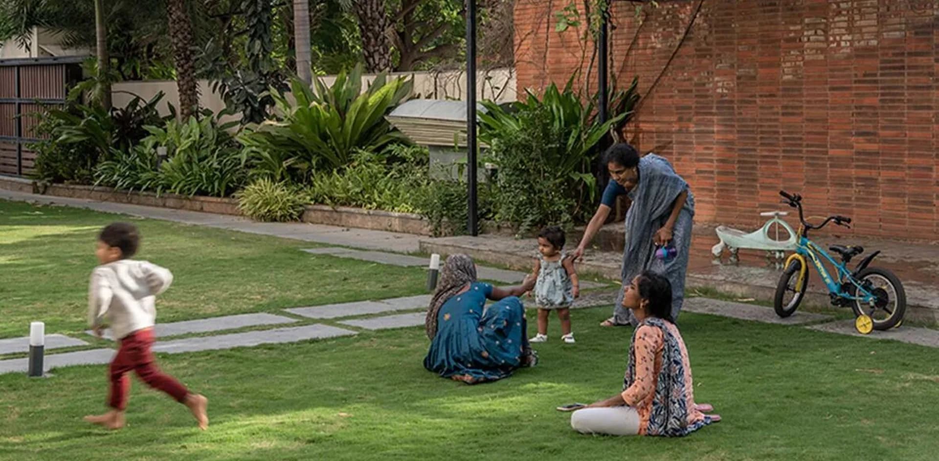 A family relaxing and children playing on a shared lawn