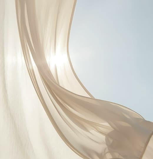 Sheer curtain lifting in the breeze